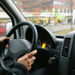 person-holding-steering-wheel-of-ca
