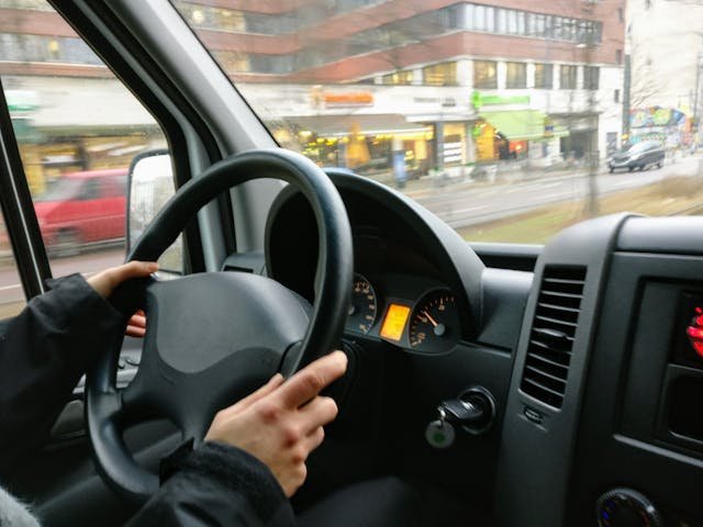 person-holding-steering-wheel-of-ca
