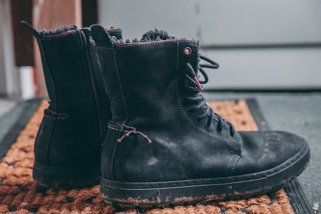 pair-of-black-lace-up-boots-on-area-rug-